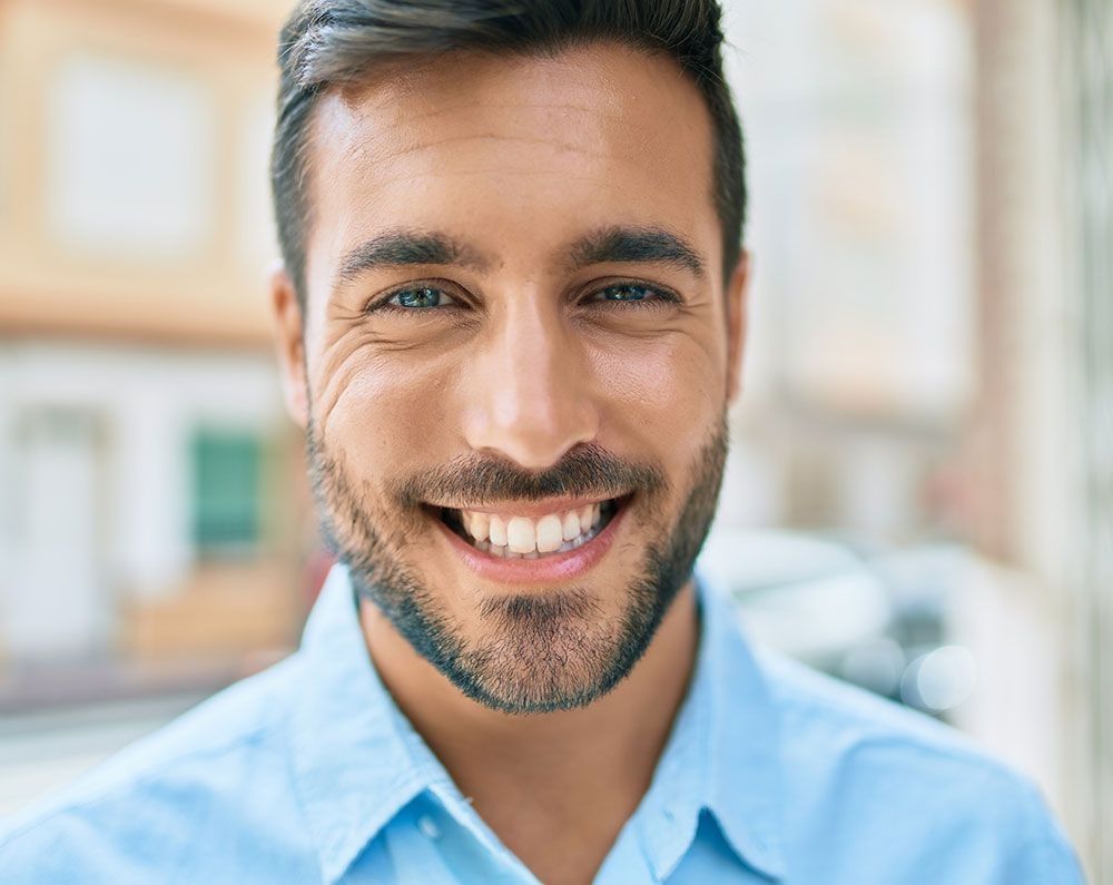 Mann mit freundlichem Lächeln und gepflegtem Gebiss in Nahaufnahme