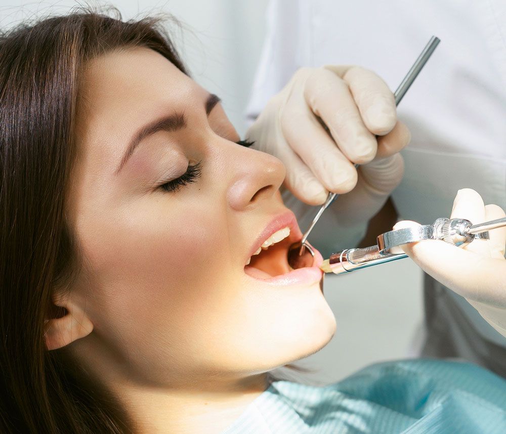 Zahnärztliche Behandlung mit Betäubungsspritze bei geöffneter Mundhöhle.